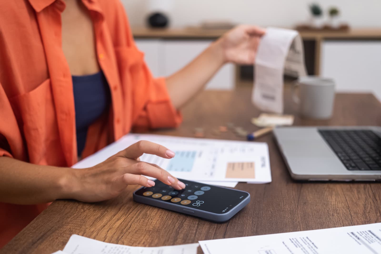 Manos calculando el IVA de una factura con el móvil