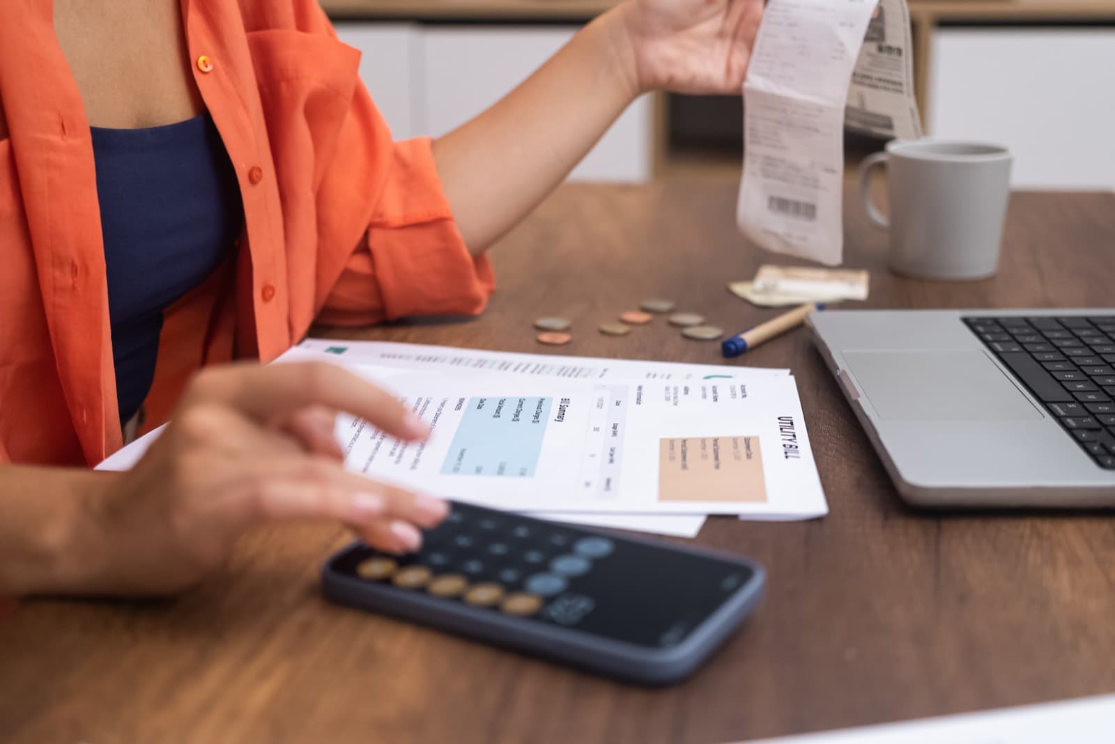 Factura en papel, calculadora y portátil sobre una mesa de trabajo